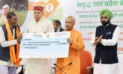 लखनऊ में शनिवार को एक कार्यक्रम में किसान को सहायता राशि का चेक प्रदान करते उत्तर प्रदेश के मुख्यमंत- India TV Paisa