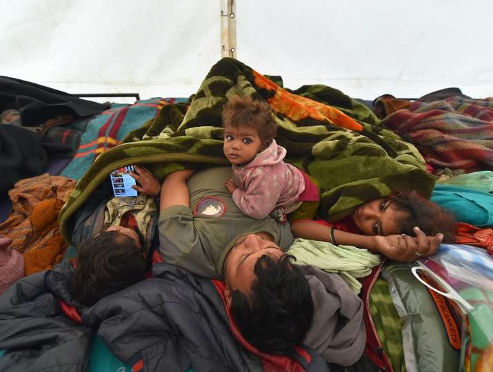 A family at a night shelter at Saraikale Khan during a cold morning in New Delhi