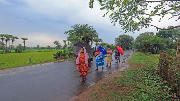 Villagers walk along a deserted road during rain ahead of cyclone 'Amphan' landfall, at Kasba in Birbhum district on Wednesday.