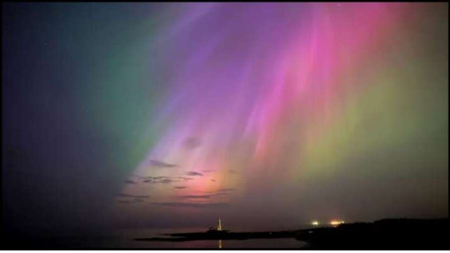 The aurora borealis glow on the horizon at St. Mary's Lighthouse in Whitley Bay on the North East co