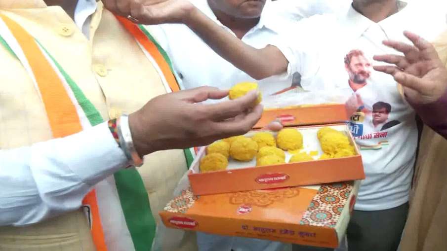 Congress workers celebrating by feeding each other laddus