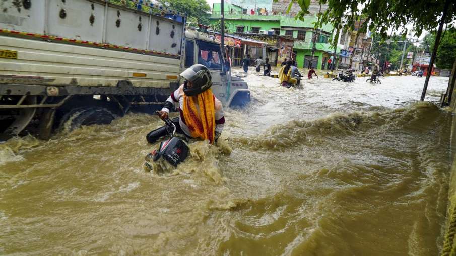वाराणसी में बाढ़ के बीच जाते लोग
