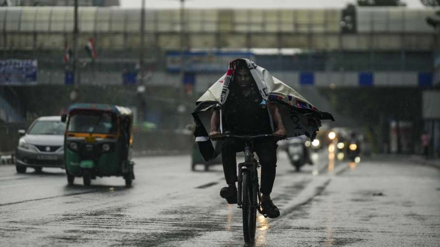 बारिश से खुद को बचाता साइकिल सवार
