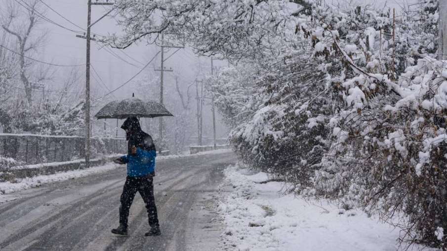 बर्फबारी के बीच जाता हुआ युवक
