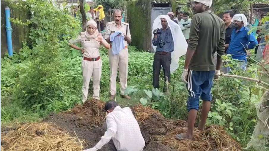 गोबर के ढेर में डबे बच्चे के शव को निकालते लोग