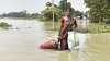 तस्‍वीर असम के मोरीगांव की हैै जहां  महिला बाढ़ के बीच घर के लिए सिलेंडर लेकर आ रही है। 