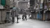  Paramilitary soldiers stand guard on a deserted street...- India TV Hindi