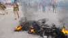 Smoke billows out of a charred vehicle as a protest against...- India TV Hindi
