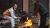 People warm themselves around a bonfire- India TV Hindi
