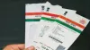 एक व्‍यक्ति आधार कार्ड की कुछ प्रतियां हाथ में पकड़़े़े हुुुुए। - India TV Paisa