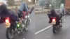चलती बाइक पर लेटकर फोन चलाता हुआ युवक।- India TV Hindi