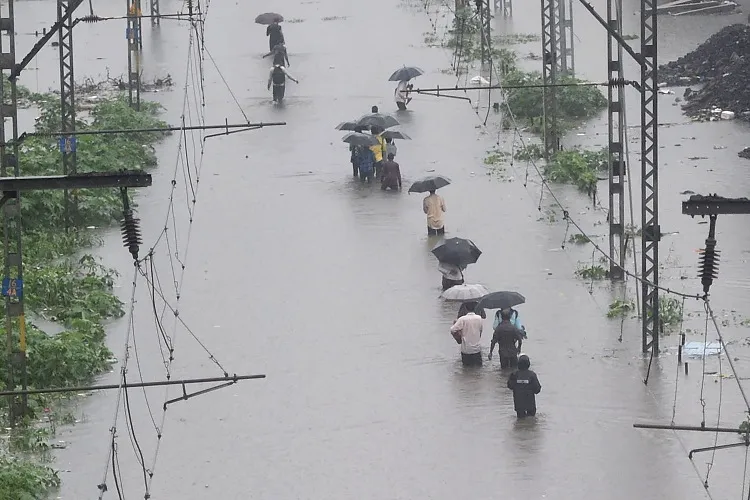 Mumbai Rain: मूसलाधार बारिश से मायानगरी बेहाल, मृतकों की संख्या 35 पर पहुंची <p>People walk on the waterlogged railway tracks during...- India TV Hindi