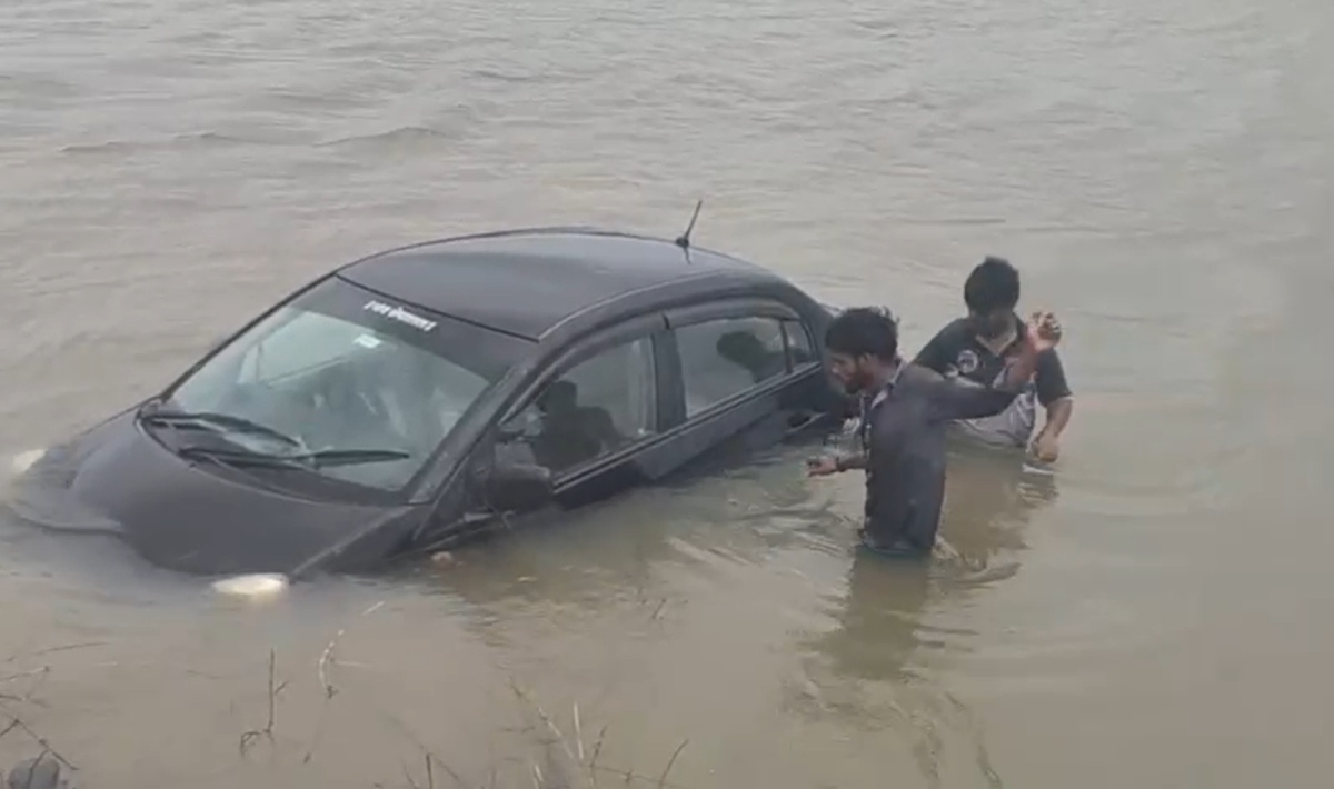 कुत्ते को बचाने के चक्कर में सड़क किनारे भरे पानी में गिरी कार, बाल-बाल बचे चार लोग