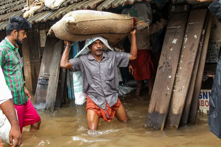 A person carries a grain sack as his house gets flooded...- India TV Hindi