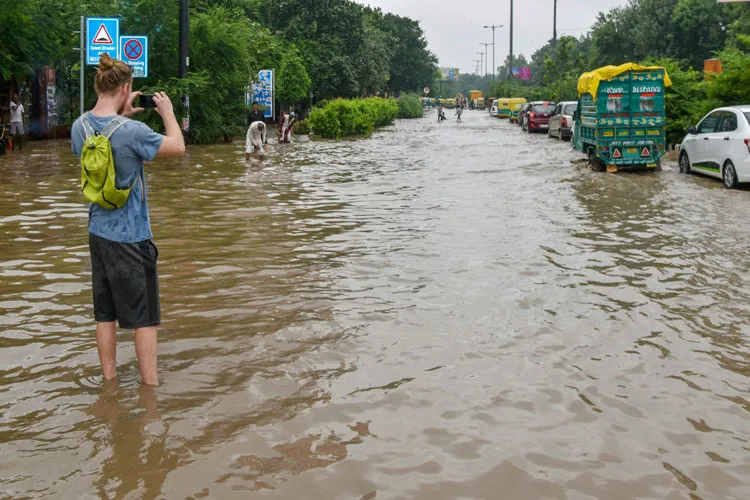 A person takes a photo while standing on a waterlogged...- India TV Hindi