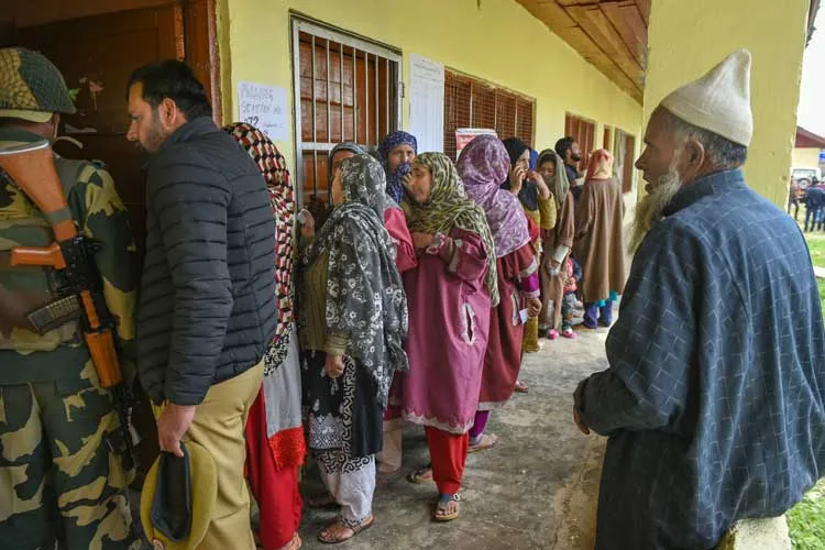 Voters wait in a long queue to cast their votes for the...- India TV Hindi