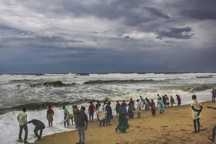 Villagers at the beach as dark clouds hover above the sea...- India TV Hindi