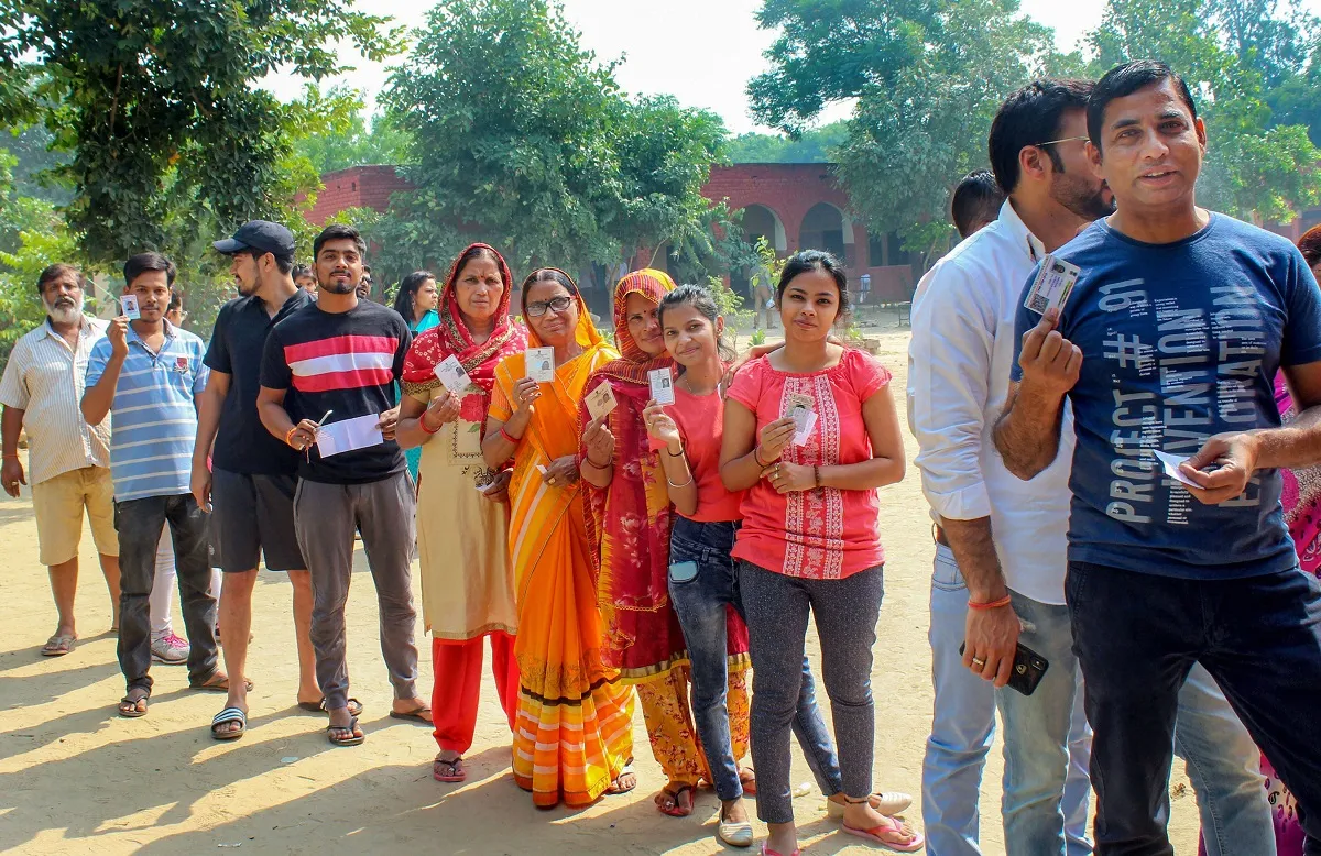  Voters stand in a queue to cast their votes at a polling...- India TV Hindi
