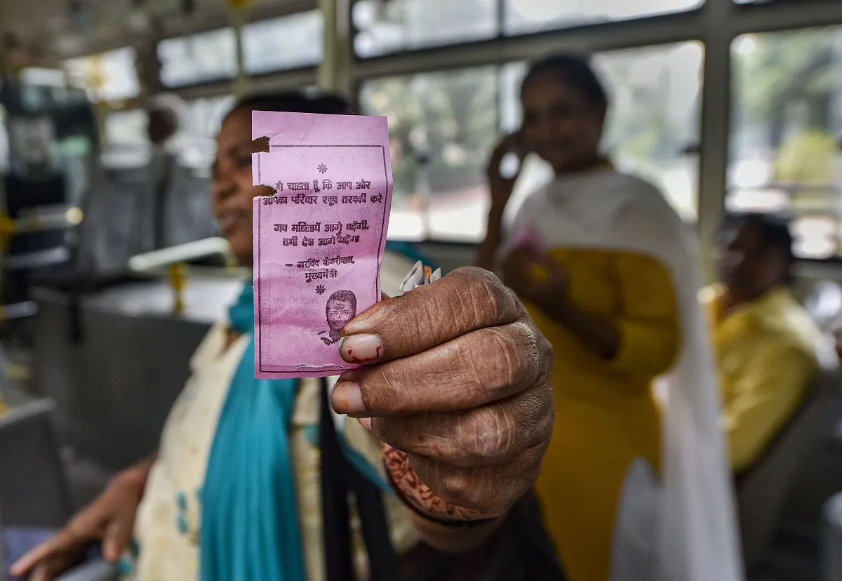 A woman shows the 'pink ticket' during her ride on a DTC...- India TV Hindi