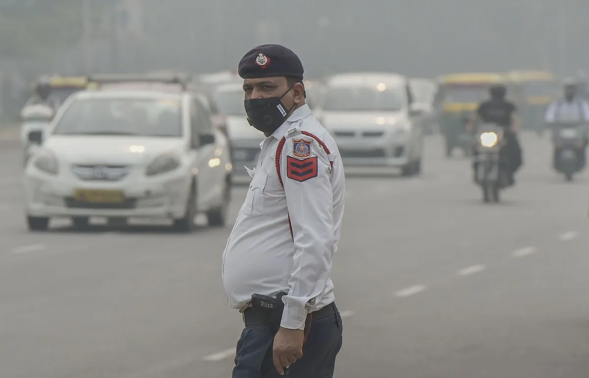 A traffic policeman wearing an anti-pollution mask diverts...- India TV Hindi