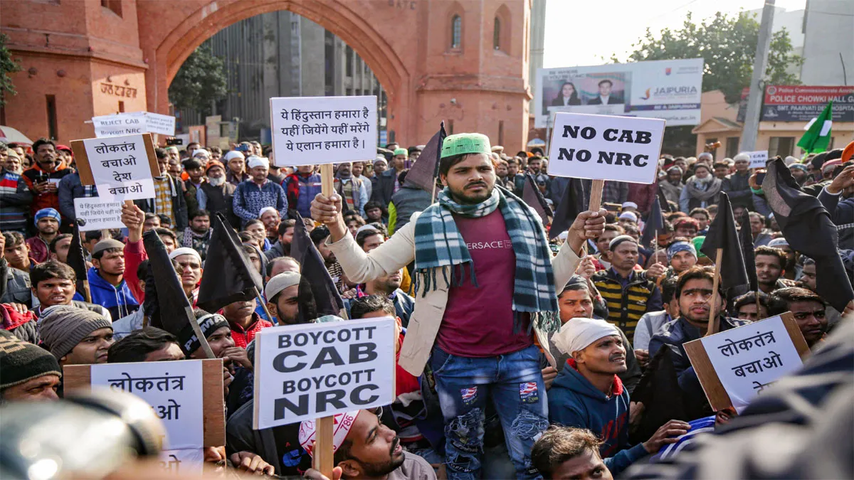 Members of Muslim community hold placards during a protest in front of the University entrance- India TV Hindi