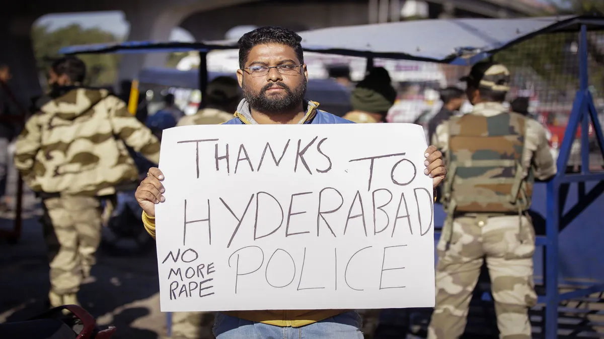 A local youth holds a placard commending the Hyderabad...- India TV Hindi