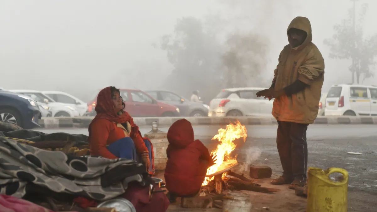People warm themselves near a bonfire during a cold and foggy morning in New Delhi.- India TV Hindi