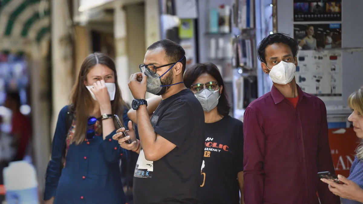 People wear protective masks to contain the spread of...- India TV Hindi