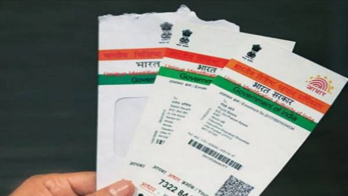 एक व्‍यक्ति आधार कार्ड की कुछ प्रतियां हाथ में पकड़़े़े हुुुुए। - India TV Paisa