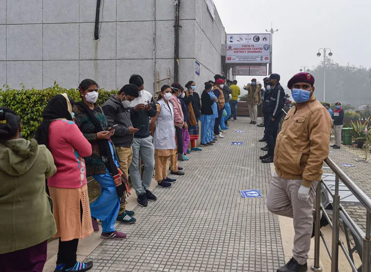 Health workers stand in a queue as they wait for their turn...- India TV Hindi
