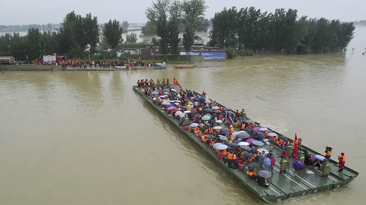 Rescuers use a motorized raft bridge to evacuate residents from a flooded rural area in Xinxiang in - India TV Hindi