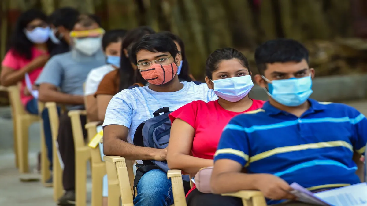 Students wait in a queue to receive COVID-19 vaccine doses during a special vaccination drive for th- India TV Paisa