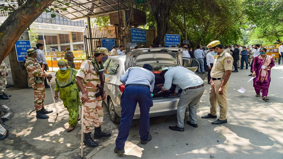 Delhi Police personnel check a vehicle at the Rohini Court, a day after the shooting incident, in Ne- India TV Hindi