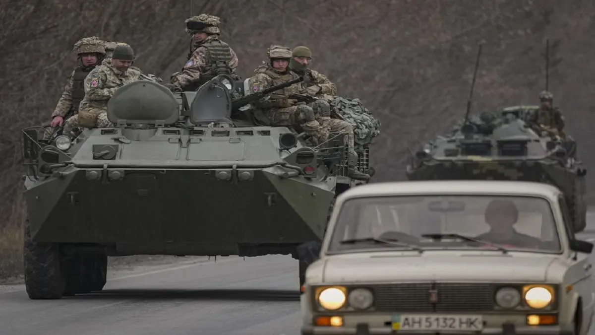Ukrainian servicemen sit atop armored personnel carriers driving on a road in the Donetsk region, ea- India TV Hindi