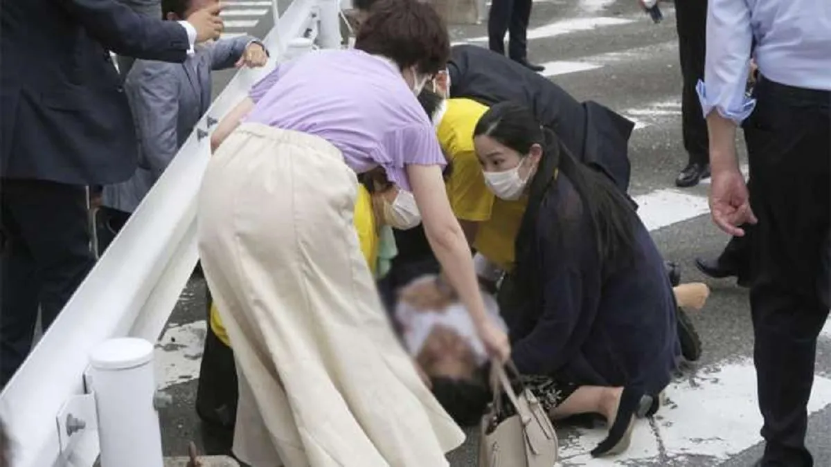 Japan’s former Prime Minister Shinzo Abe, center, falls on the ground in Nara, western Japan Friday,- India TV Hindi