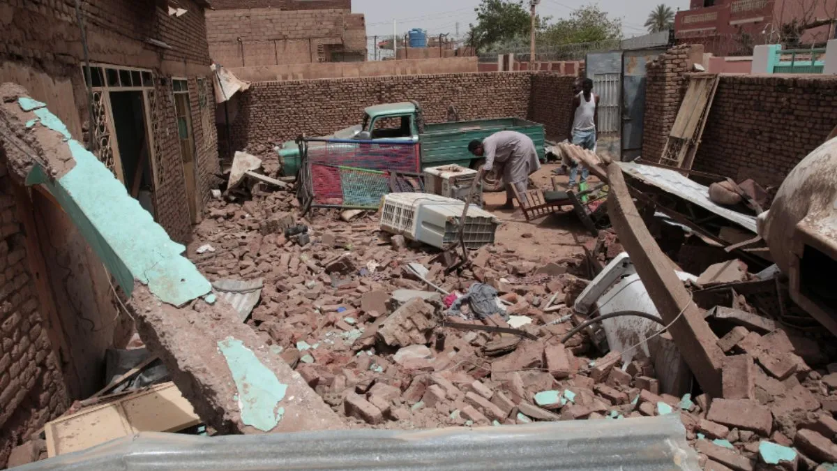 A man cleans debris of a house hit in recent fighting in Khartoum, Sudan- India TV Hindi