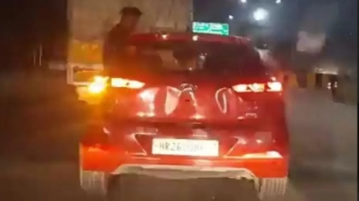 कार से लटकता हुआ युवक।- India TV Hindi