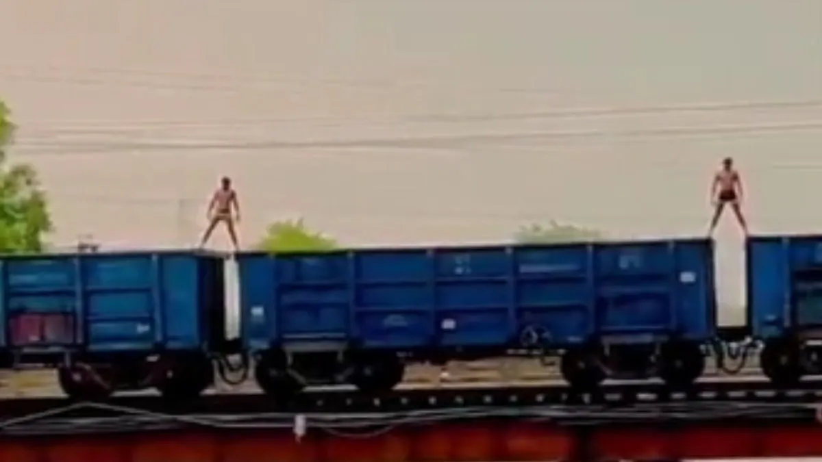 ट्रेन पर चढ़कर स्टंट दिखाते हुए युवक।- India TV Hindi