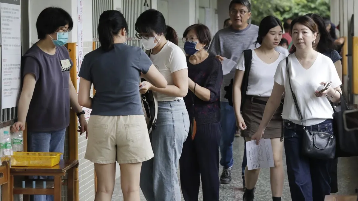 ताइवान में चीन समर्थक सांसदों को हटाने के लिए वोट करते लोग।