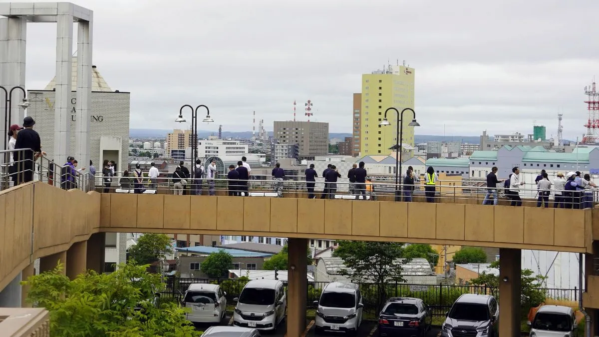 सुनामी के अलर्ट के बाद ऊंचाई पर खड़े लोग। - India TV Hindi