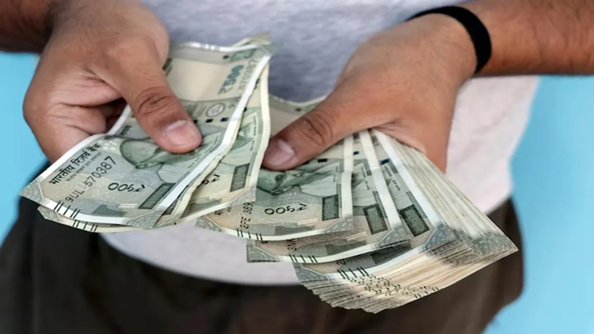 500 रुपये के नोट गिनता एक शख्स।- India TV Hindi