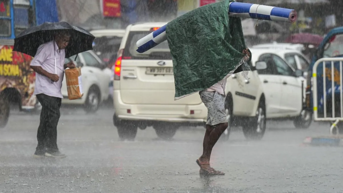 कोलकाता में बारिश के दौरान जाते लोग- India TV Hindi
