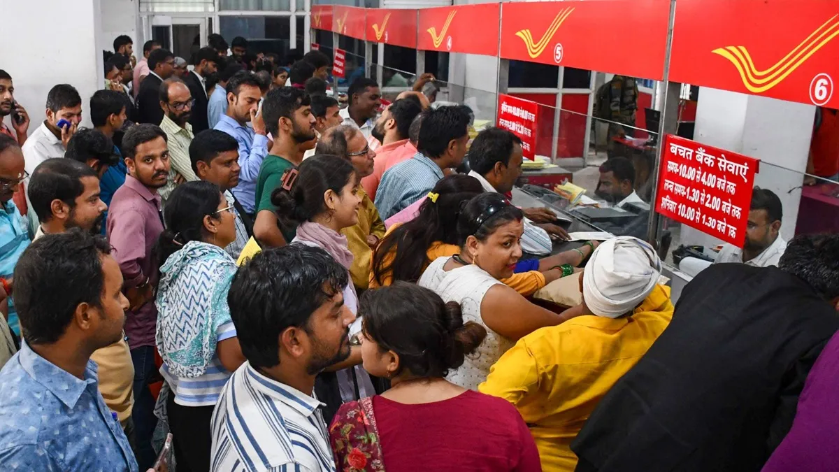 पोस्ट ऑफिस की एक शाखा में काउंटर पर अपनी बारी का इंतजार करते लोग।- India TV Hindi