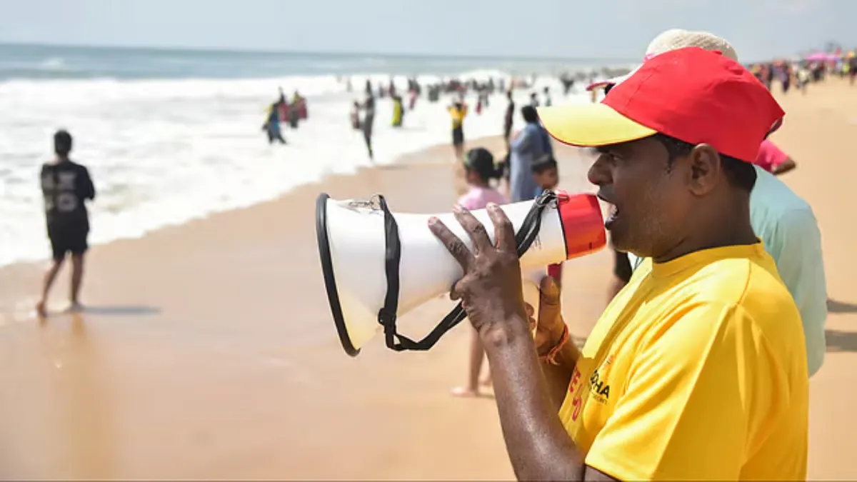 समुद्री तटों पर लोगों को अलर्ट करता हुआ एक सरकारी कर्मचारी- India TV Hindi