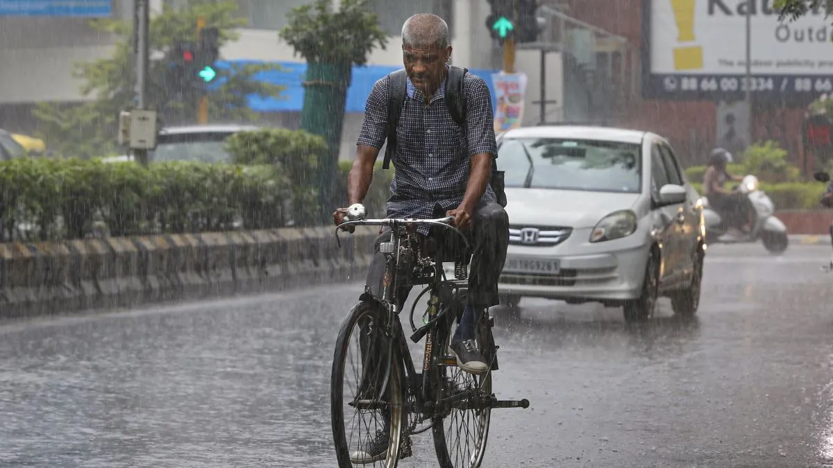 अहमदाबाद में बारिश के बीच जाते लोग- India TV Hindi