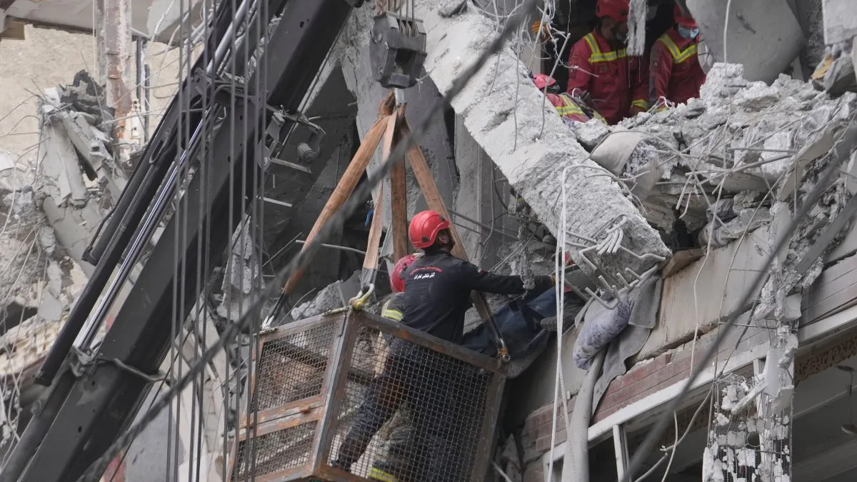 तेहरान में अमेरिकी-इजरायली हमले में क्षतिग्रस्त एक आवासीय इमारत से पीड़ित का शव बाहर निकालते बचावकर्- India TV Hindi