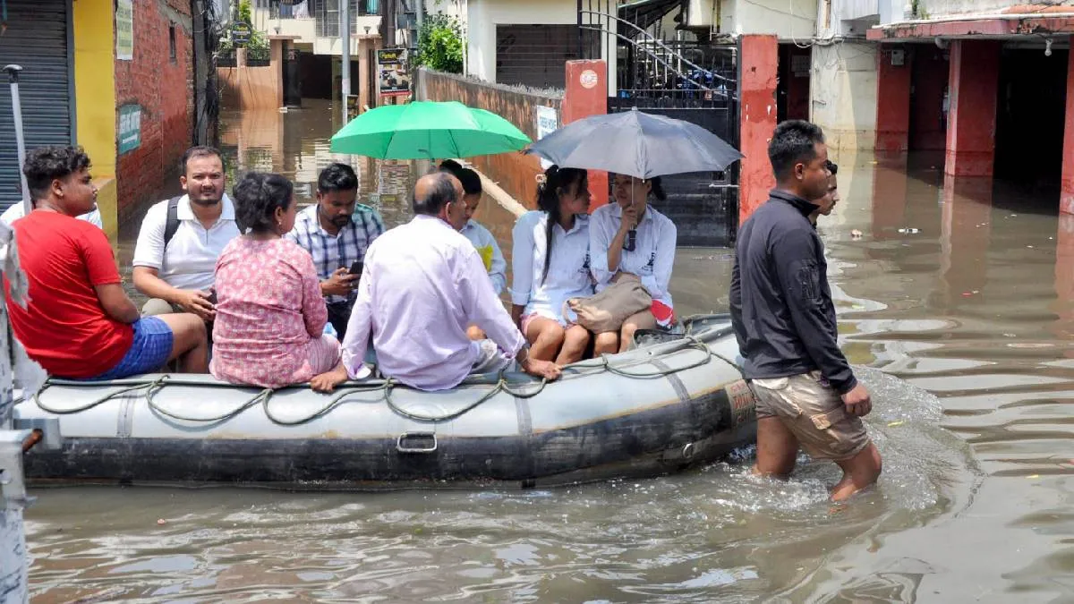 गुवाहाटी में मंगलवार को बचावकर्मी जलमग्न इलाके से नाव के ज़रिए निवासियों को बाहर निकालते हुए।- India TV Hindi