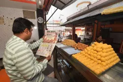 <p>Shopkeeper reads newspaper fronted with headlines on...- India TV Hindi