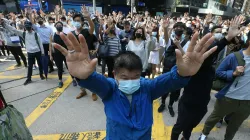 Demonstrators raise their hands during a protest in the financial district in Hong Kong.- India TV Hindi