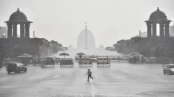 A man runs for cover as heavy rains accompanied by hailstorm lashed parts of the national capital, a- India TV Hindi